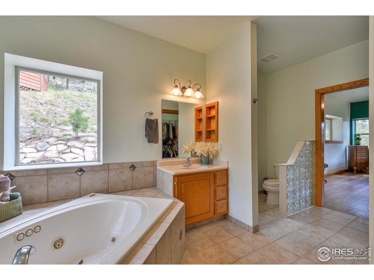 560 Stove Prairie Road Bellvue, CO 80512 - Photo 19 of 40 a bathroom with a tub a sink and a large mirror