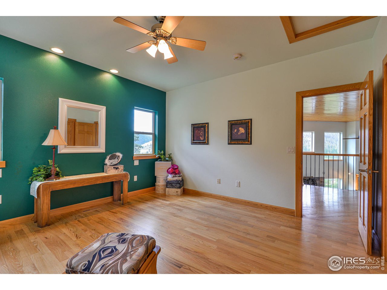 560 Stove Prairie Road Bellvue, CO 80512 - Photo 24 of 40 a bedroom with a bed and a chandelier
