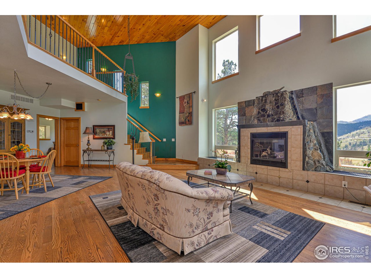 560 Stove Prairie Road Bellvue, CO 80512 - Photo 5 of 40 a living room with furniture a wooden floor and a fireplace