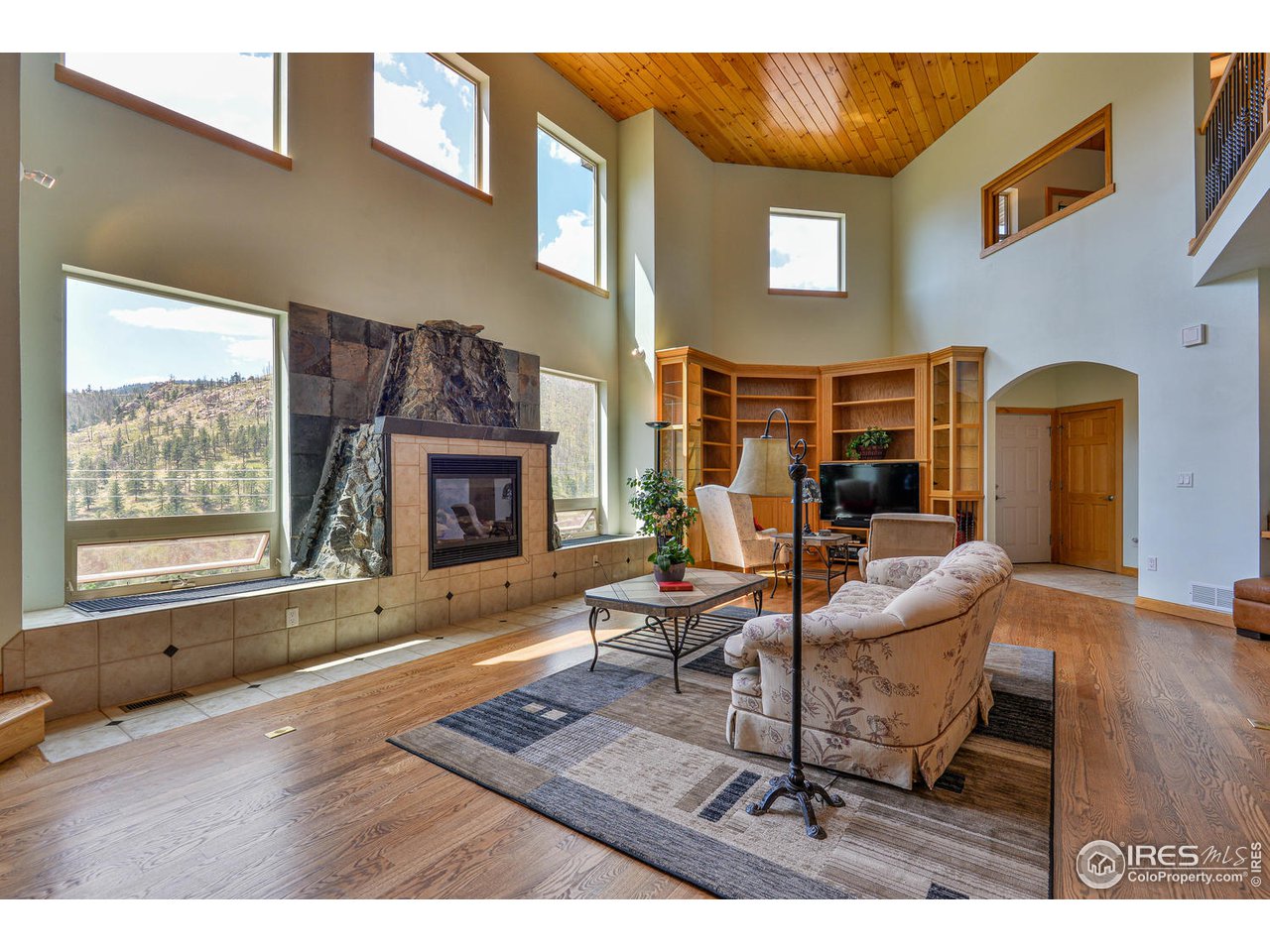 560 Stove Prairie Road Bellvue, CO 80512 - Photo 6 of 40 a living room with furniture wooden floor and a fireplace