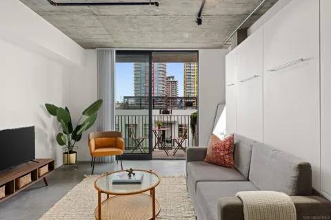 a living room with furniture a flat screen tv and a table