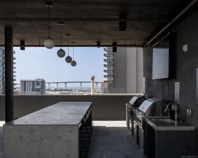 a view of a patio with a table chairs and a barbeque