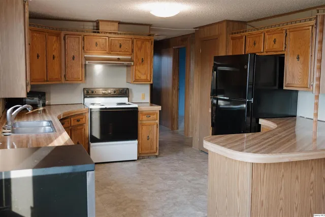 a kitchen with stainless steel appliances granite countertop a refrigerator stove and sink