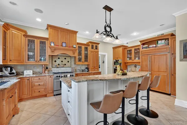 a kitchen with stainless steel appliances granite countertop a stove top oven a sink dishwasher and white cabinets with wooden floor