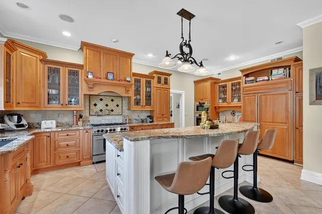 a kitchen with stainless steel appliances granite countertop a stove top oven a sink dishwasher and white cabinets with wooden floor