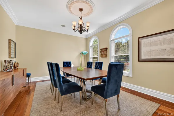 a view of a dining room with furniture a chandelier and wooden floor