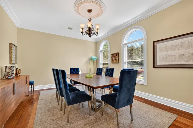 a view of a dining room with furniture a chandelier and wooden floor