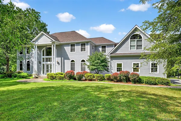 a front view of a house with a garden and plants