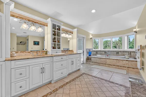 a bathroom with a granite countertop sink and a window
