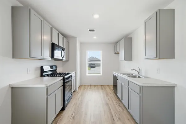 a kitchen with a sink stove top oven and cabinets