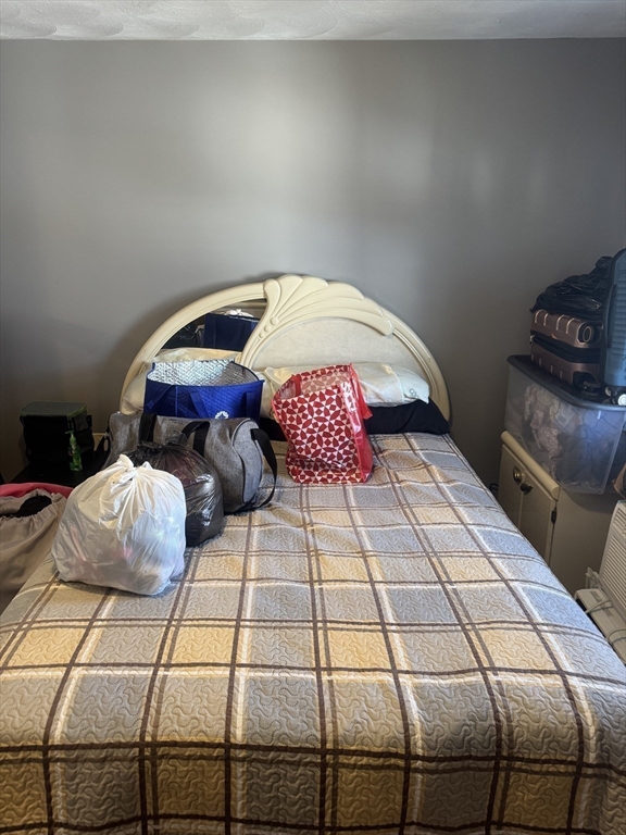 21 Cook, Unit 1 Chelsea, MA 02150 - Photo 15 of 32 a bedroom with a bed and a lamp