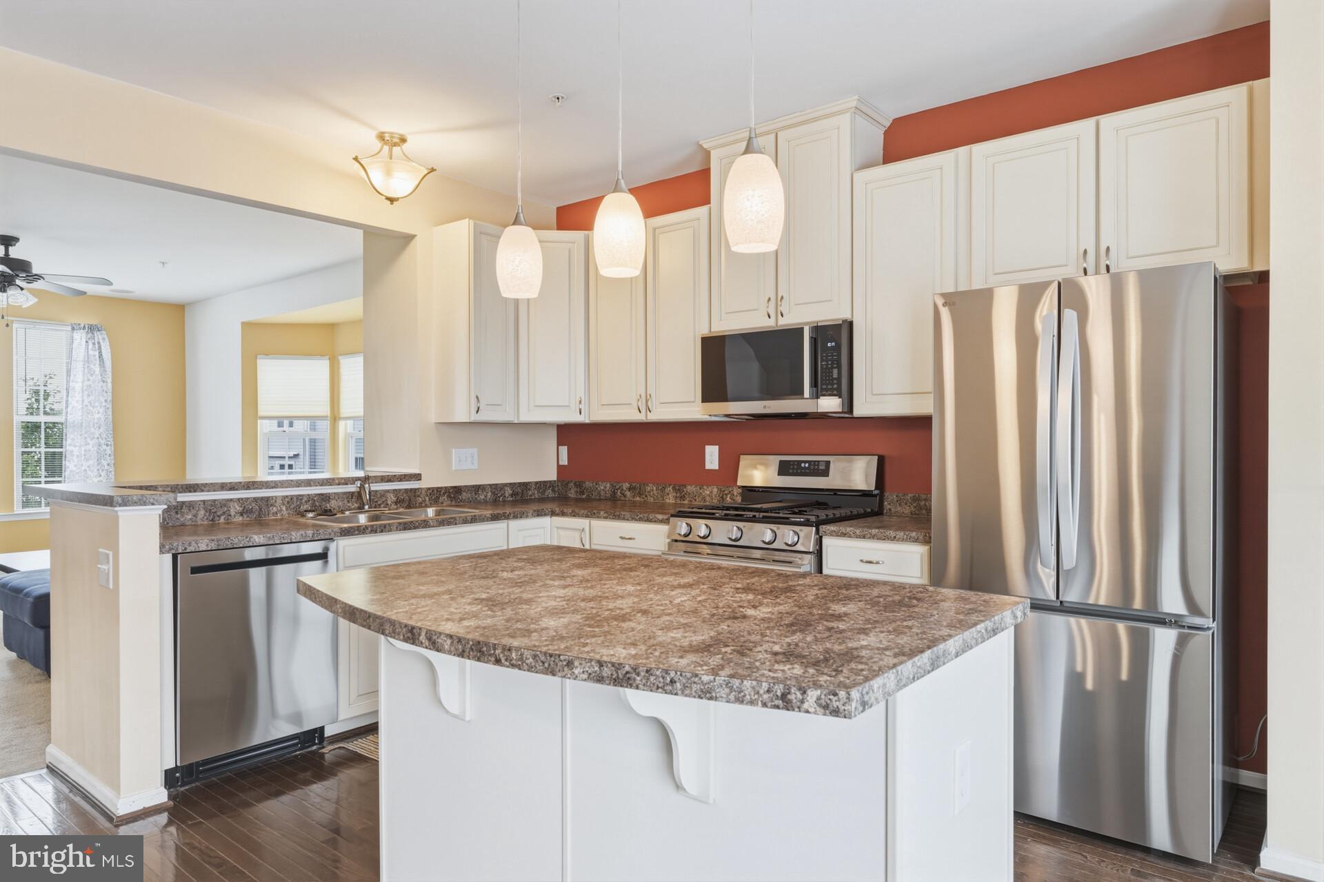 325 Schmidt Road Phoenixville, PA 19460 - Photo 14 of 27 a kitchen with stainless steel appliances granite countertop a refrigerator a stove and a sink with wooden floor