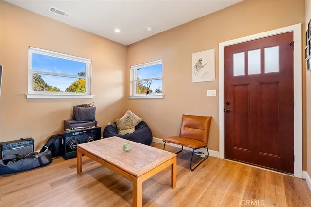 a view of a hallway with wooden floor and furniture