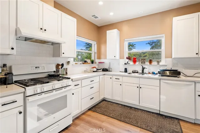 a kitchen with stainless steel appliances a refrigerator and wooden floor