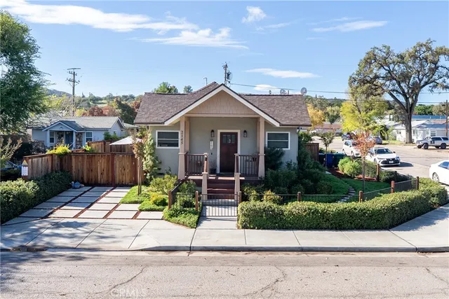 a front view of a house with a yard and potted plants