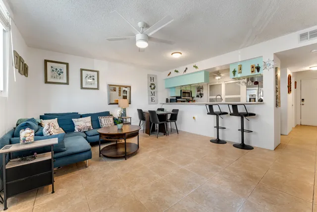 a living room with furniture and kitchen view