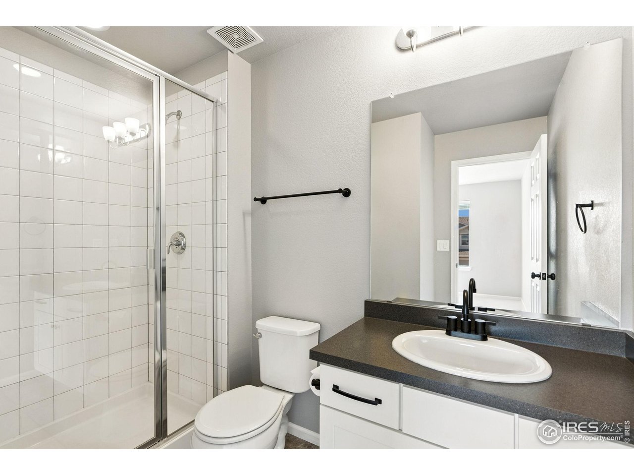 6420 Tuxedo Park Road Timnath, CO 80547 - Photo 22 of 44 a bathroom with a sink toilet a mirror and shower