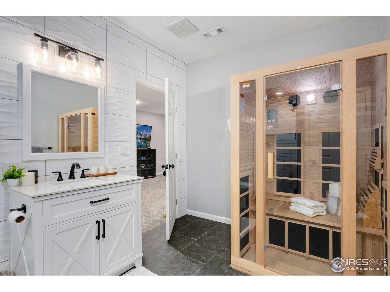 6420 Tuxedo Park Road Timnath, CO 80547 - Photo 24 of 44 a bathroom with a sink a mirror and shower