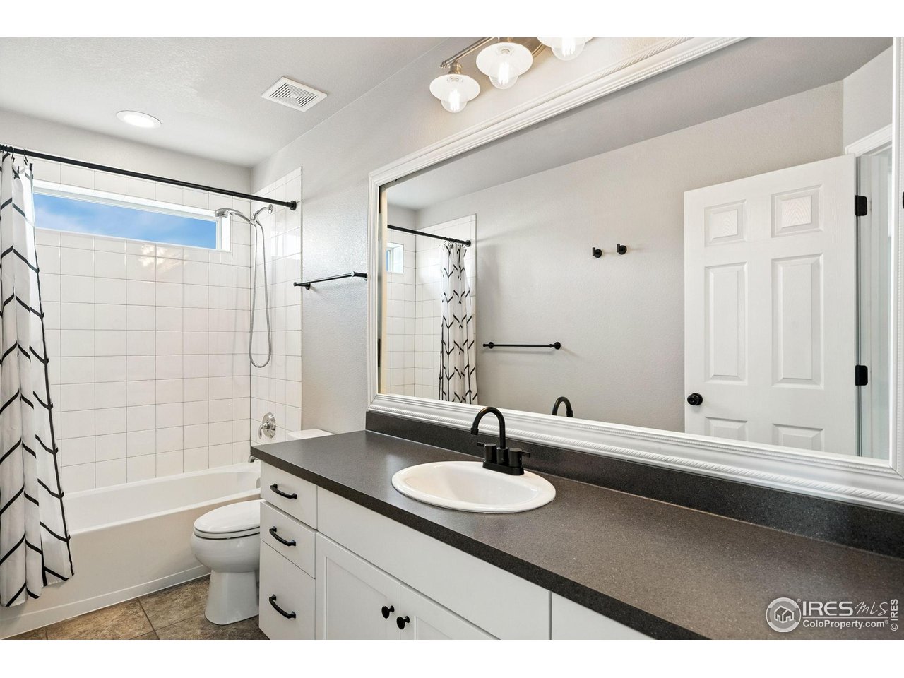 6420 Tuxedo Park Road Timnath, CO 80547 - Photo 41 of 44 a bathroom with a granite countertop sink toilet a mirror and shower