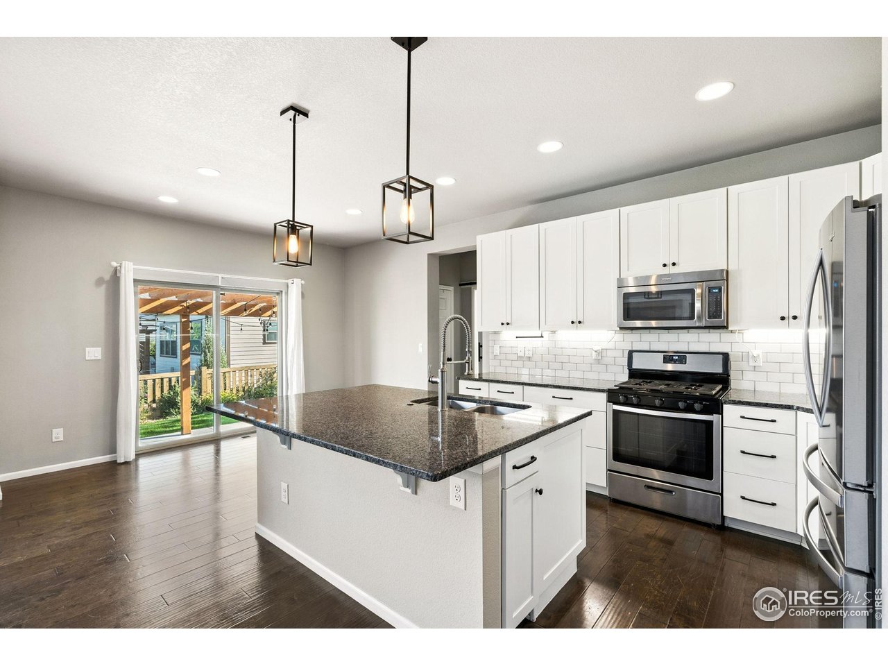 6420 Tuxedo Park Road Timnath, CO 80547 - Photo 5 of 44 a kitchen with stainless steel appliances granite countertop a sink a stove and a refrigerator