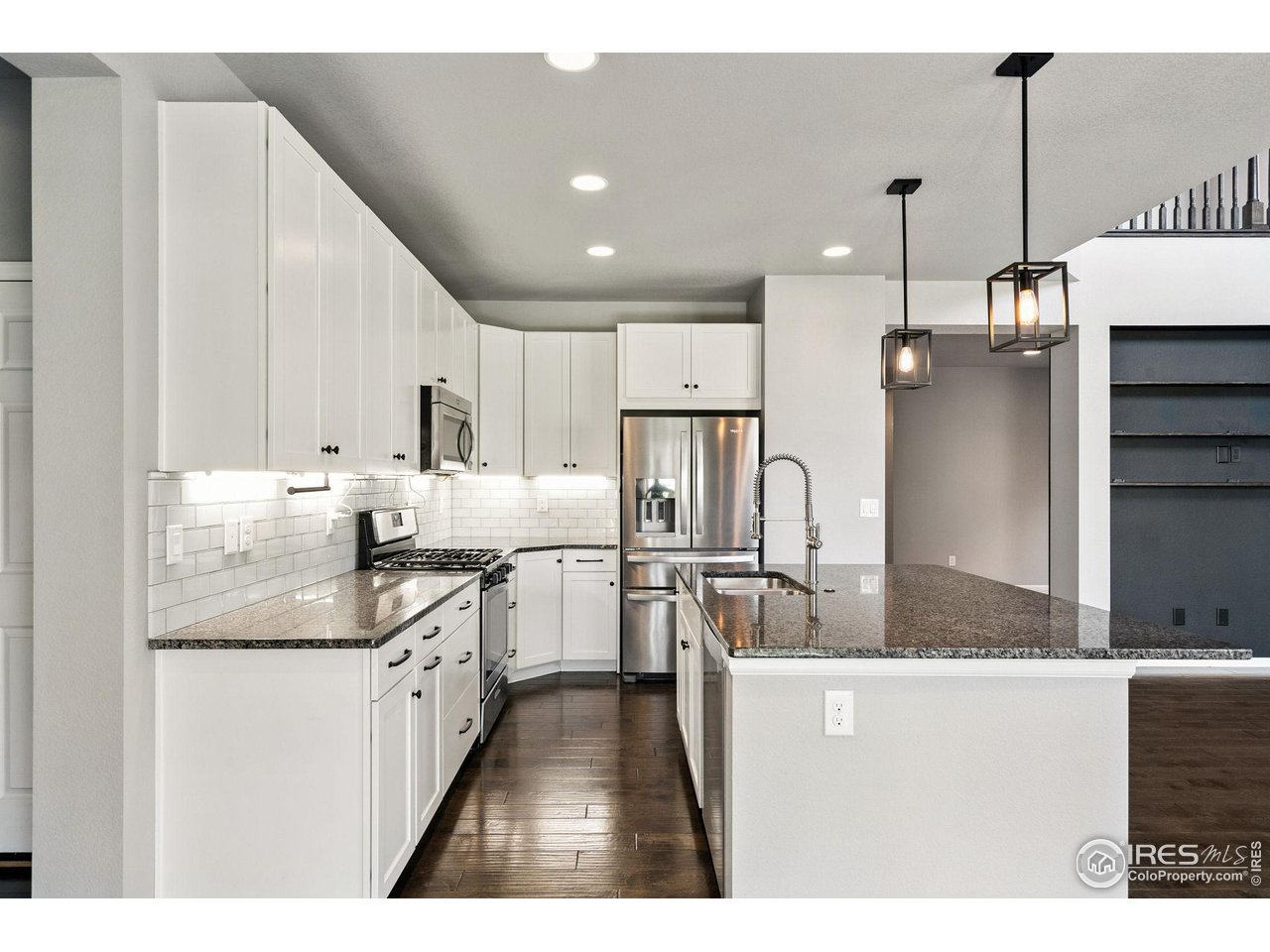 6420 Tuxedo Park Road Timnath, CO 80547 - Photo 6 of 44 a kitchen with stainless steel appliances granite countertop a sink a stove and a refrigerator