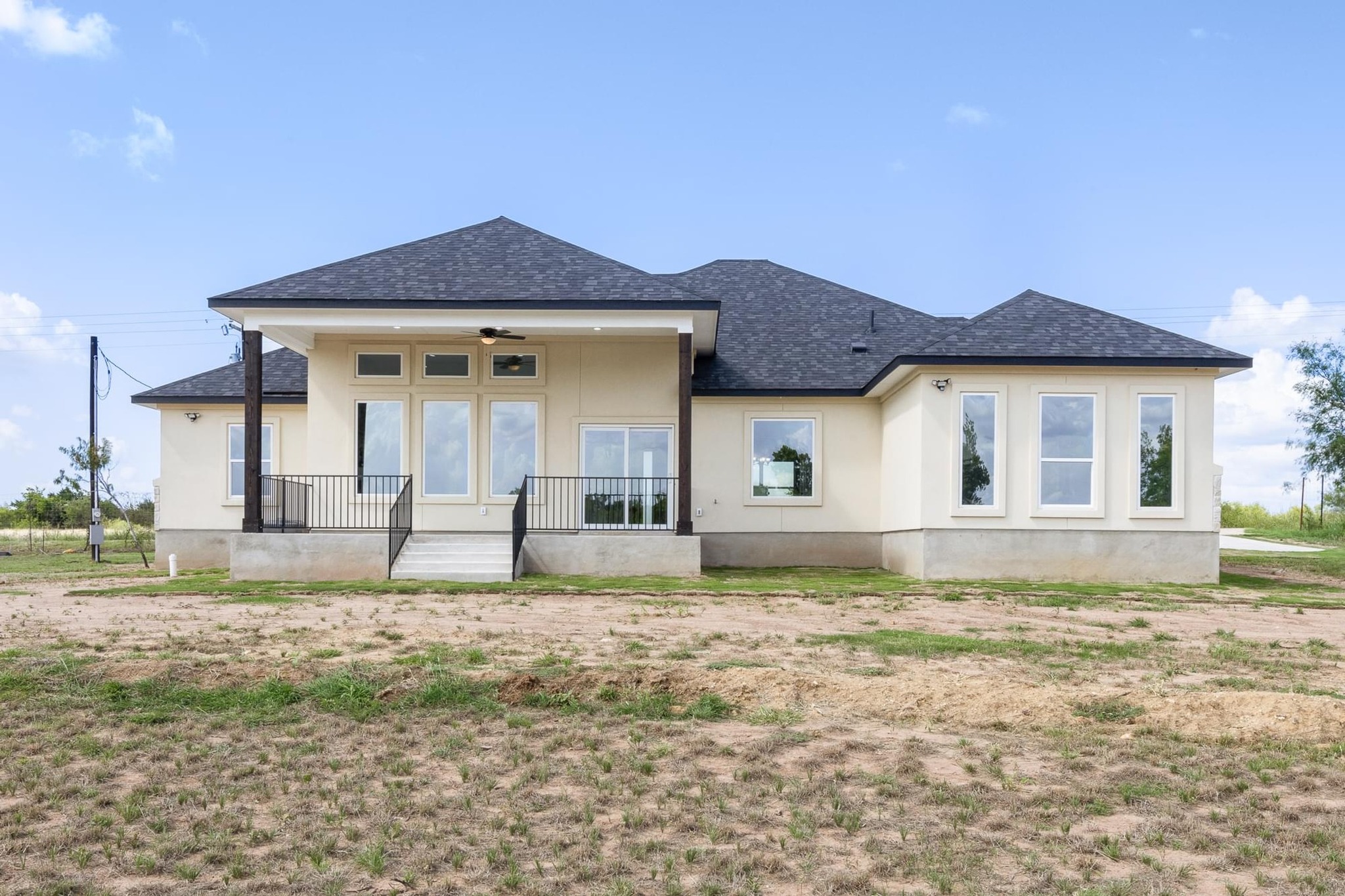 1136 County Road 484 Elgin, TX 78621 - Photo 28 of 37 Rear view of property featuring a shingled roof, covered porch, a ceiling fan, and stucco siding