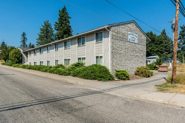 a front view of a house with a yard and potted plants