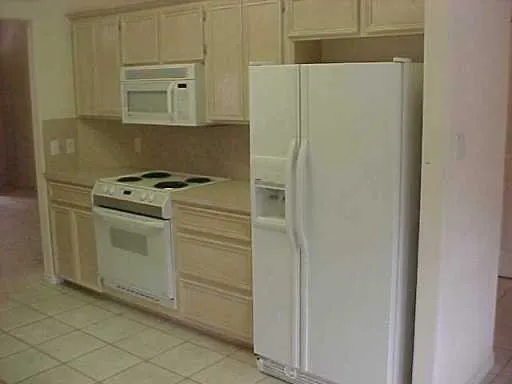 a kitchen with white cabinets and white appliances