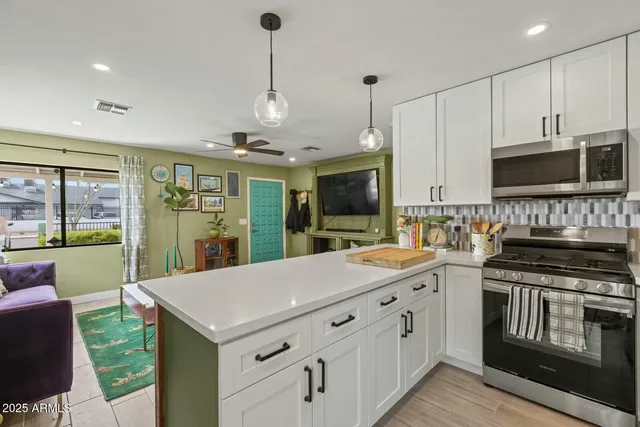 a kitchen with stainless steel appliances granite countertop a stove a sink and a microwave