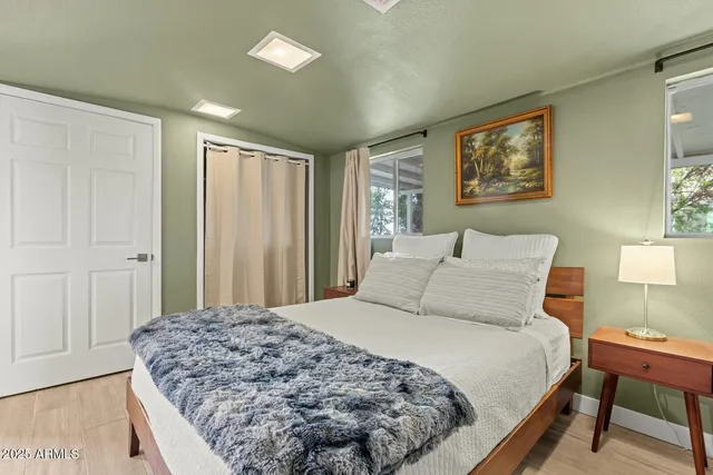 a bedroom with a large bed and a chandelier