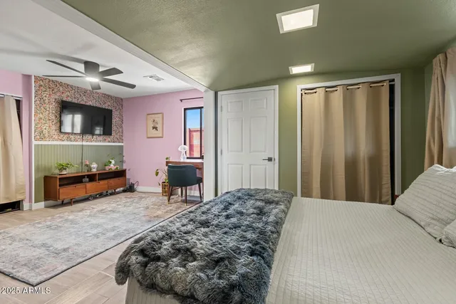 a living room with furniture a flat screen tv and a refrigerator