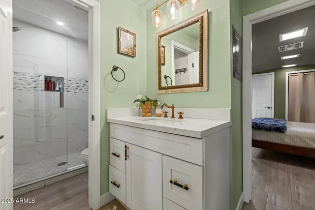 a en suite bathroom with a shower sink and mirror