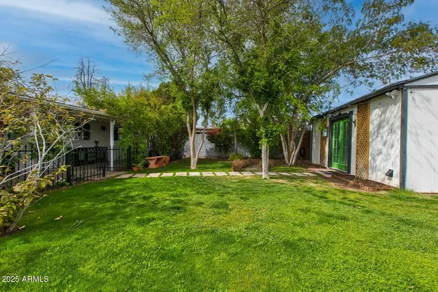 a view of a backyard with table and chairs and potted plants and large trees
