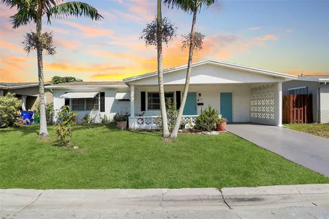 a view of a house with backyard and a tree