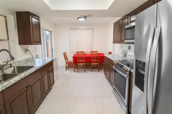 a kitchen with stainless steel appliances granite countertop a sink stove and refrigerator
