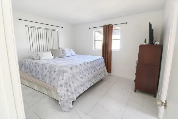 a bed sitting in a bedroom next to a window