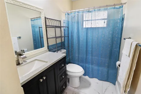 a bathroom with a sink a toilet a mirror and shower