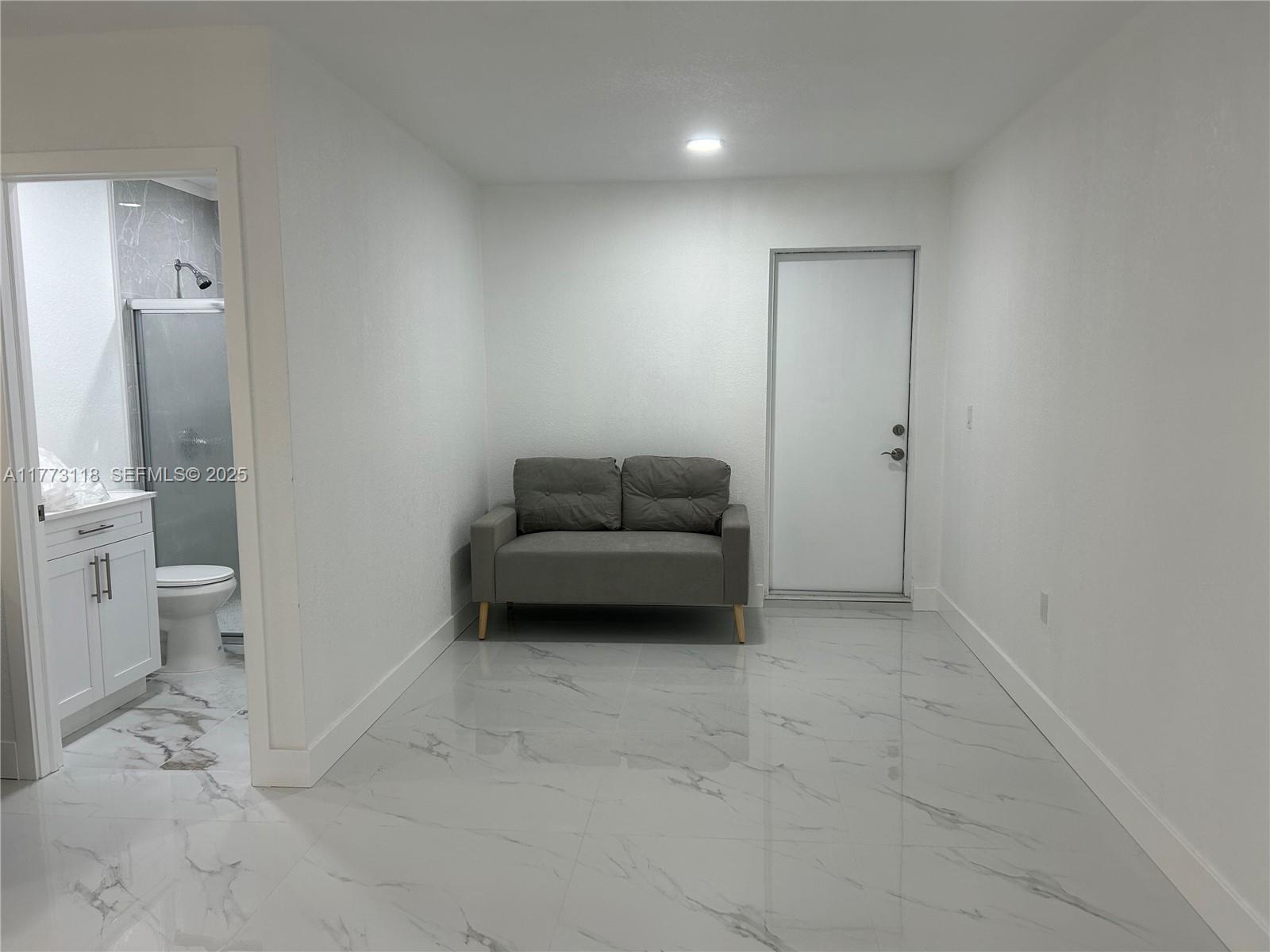 670 X Southwest 28th Terrace, Unit 1 Miami, FL 33155 - Photo 9 of 9 a room with a couch and a view of bathroom