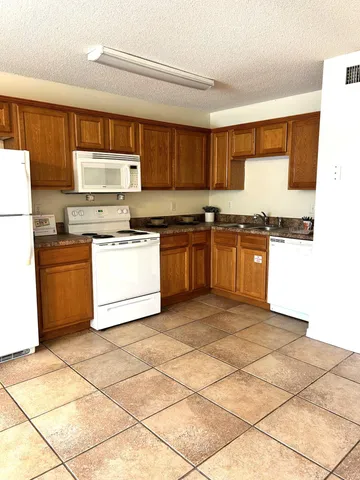 a kitchen with stainless steel appliances granite countertop a stove a sink dishwasher and a refrigerator