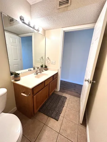 a bathroom with a sink vanity mirror and toilet