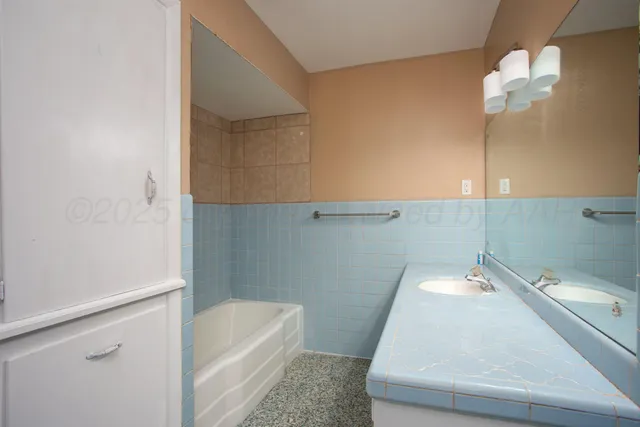a bathroom with a tub sink and vanity