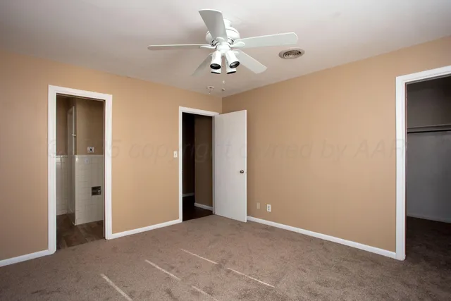 a view of an empty room with a ceiling fan
