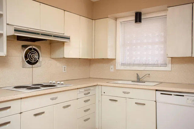 a kitchen with a sink cabinets and a window