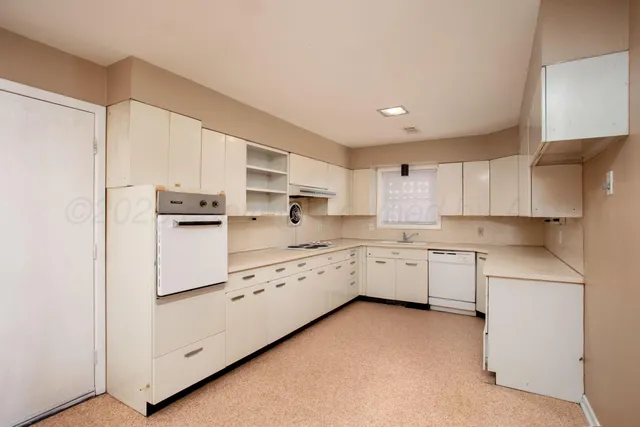 a kitchen with white cabinets and white appliances