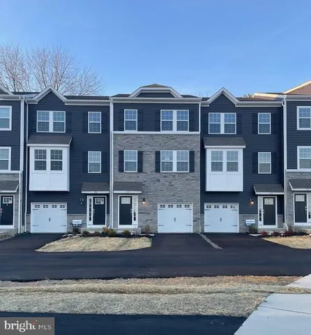 a front view of a residential apartment building with a yard