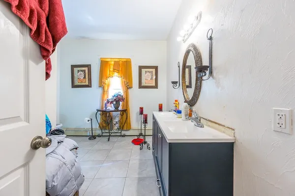 a bathroom with a sink and mirror with bathtub