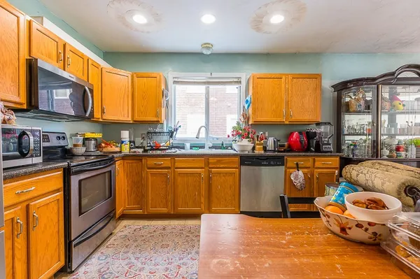 a kitchen with stainless steel appliances granite countertop a sink a stove and a refrigerator