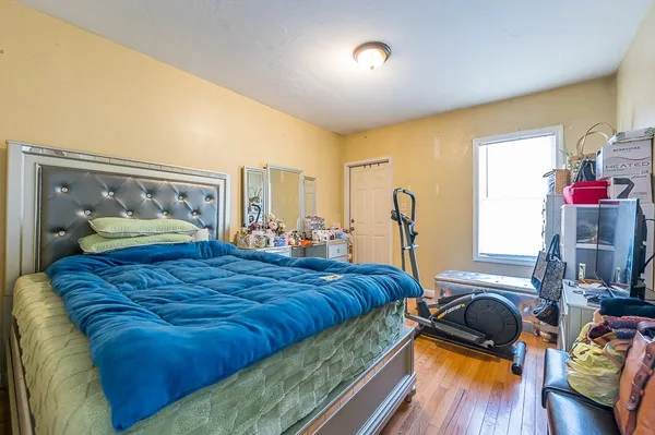 a bedroom with bed and wooden floor