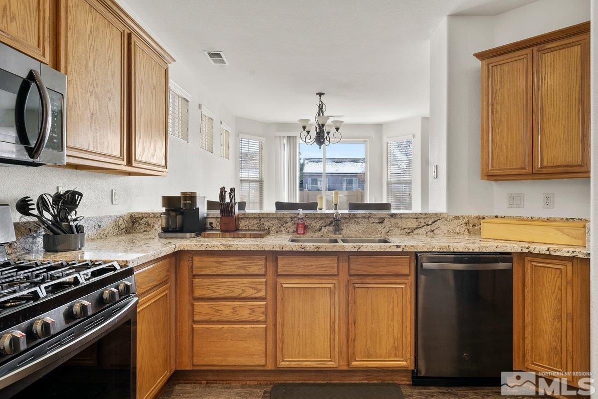 11022 Colton Drive Reno, NV 89521 - Photo 11 of 26 a kitchen with stainless steel appliances granite countertop a stove and a sink