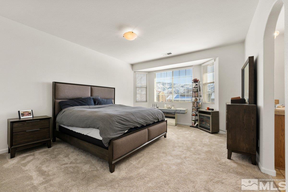11022 Colton Drive Reno, NV 89521 - Photo 14 of 26 a bedroom with a bed and a refrigerator